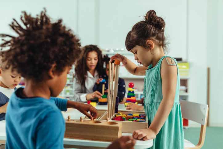 diverse children playing in a classroom center