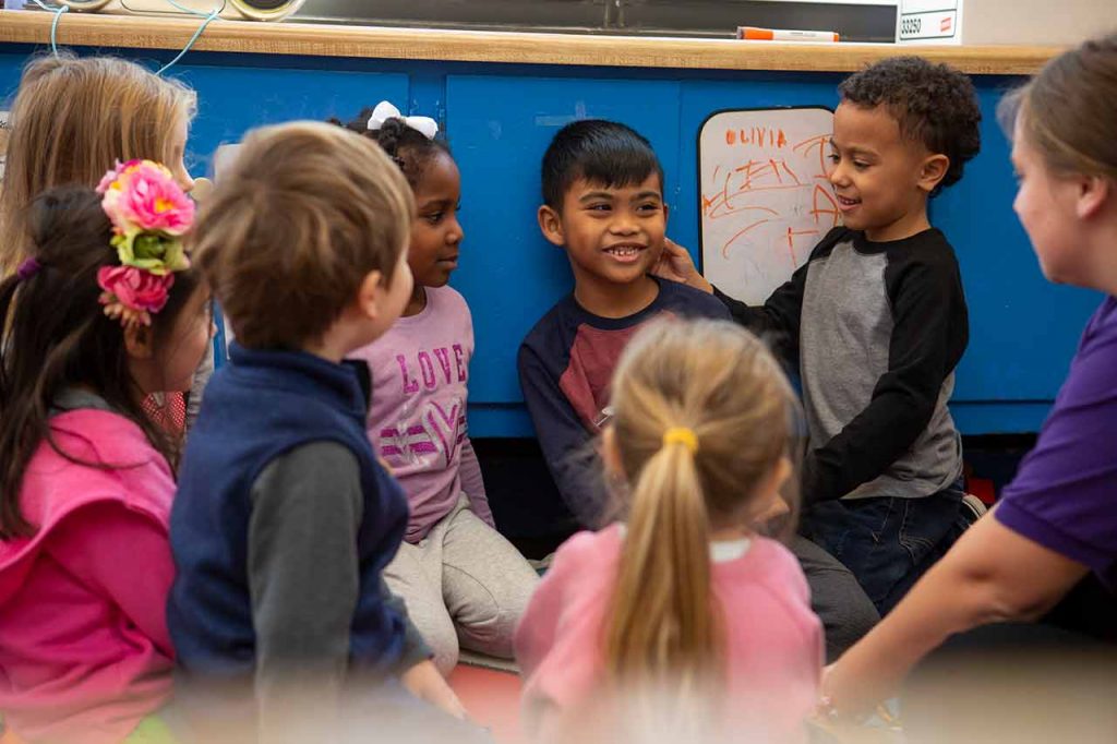 An educator guiding a morning greeting in circle time