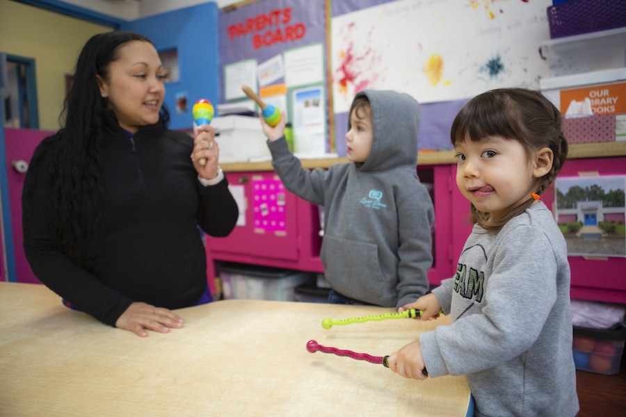 Educator and young children playing with instruments.